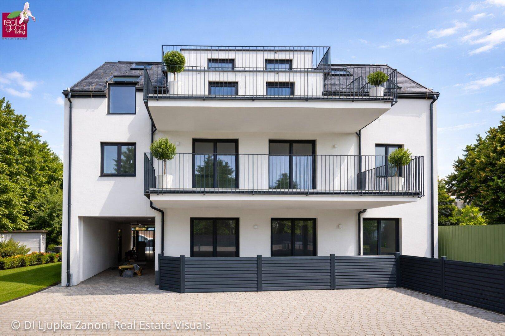 Moderne weiße Fassade des Neubaus mit Balkonen und großen Fenstern.