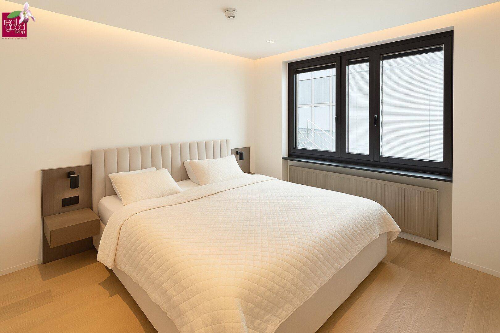Modernes Schlafzimmer mit bequemem Doppelbett, Holzboden und indirekter Beleuchtung für eine gemütliche Atmosphäre.