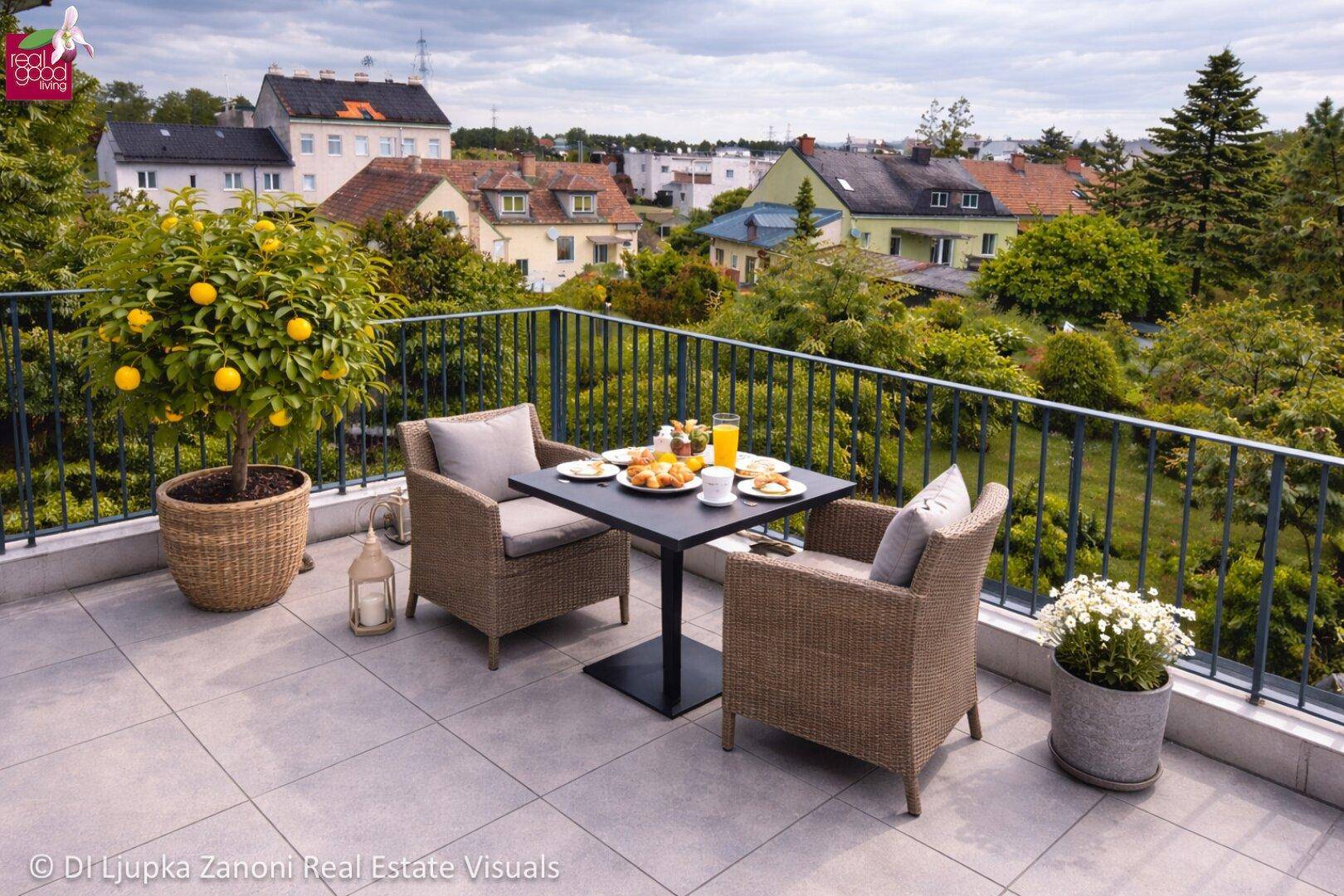 Geräumige Terrasse mit gemütlichen Sitzgelegenheiten, einem Zitronenbaum und weitem Blick über die Wohngegend.