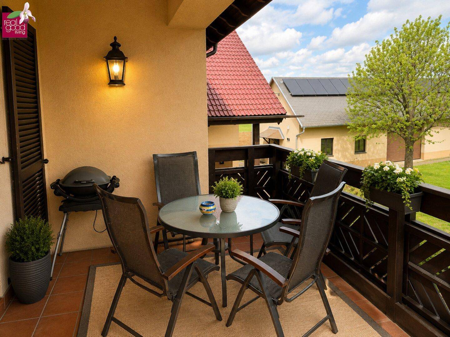Gemütlicher Balkon mit Sitzgelegenheiten, Grill und Blick auf die Umgebung.