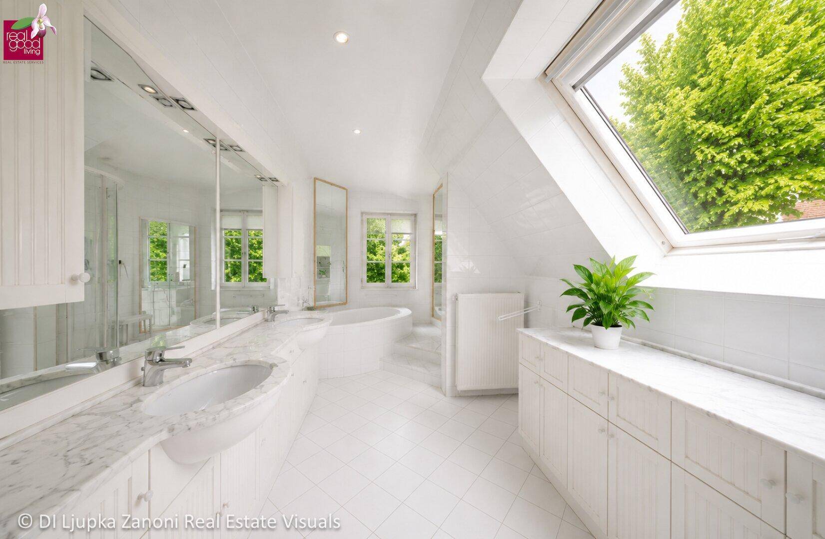 Helles Badezimmer im Dachgeschoss mit Doppelwaschbecken, Badewanne und Dachfenster.