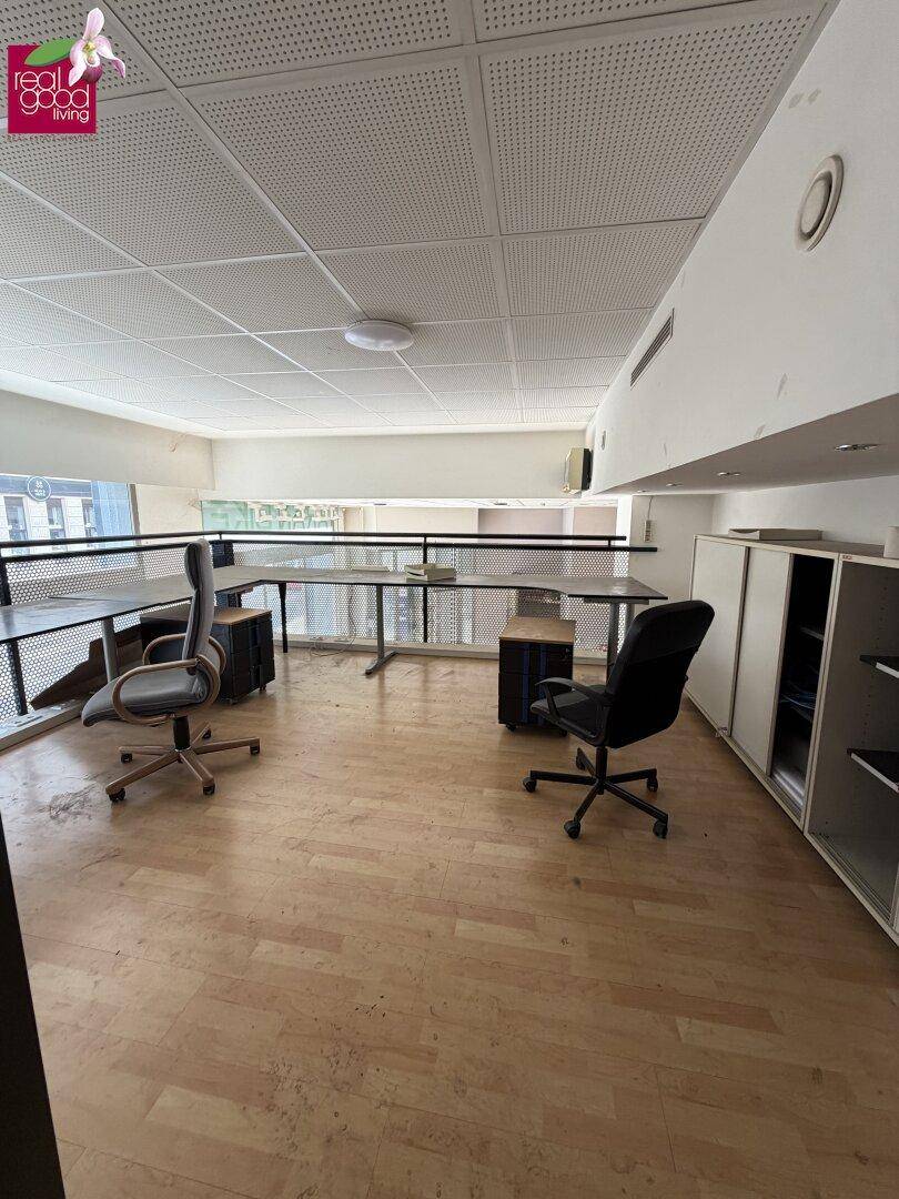 Heller Bürobereich auf einer Galerie mit Holzfußboden und Blick auf den unteren Bereich.