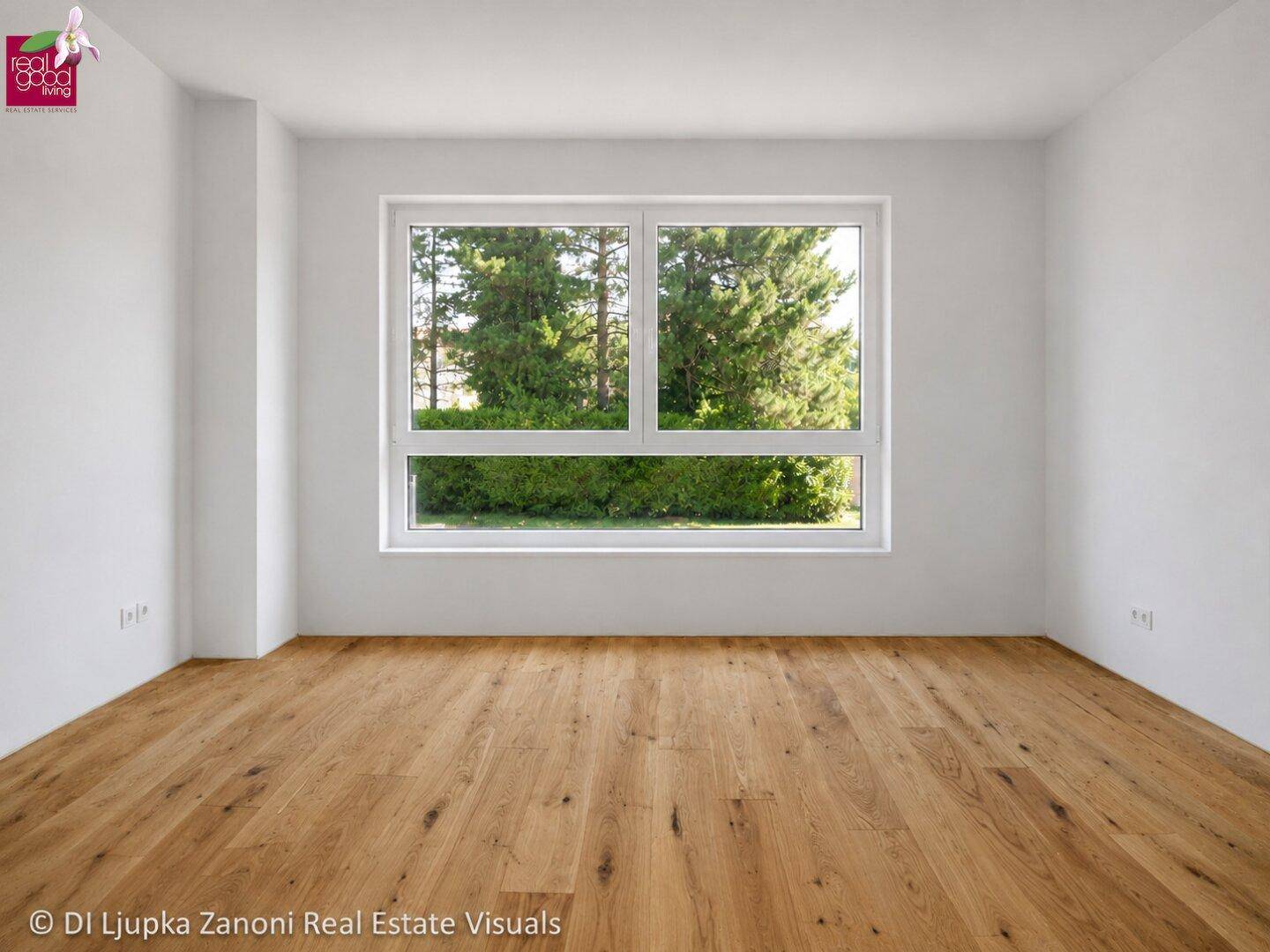 Leeres Zimmer mit Holzboden und großem Fenster, das viel Tageslicht hereinlässt.