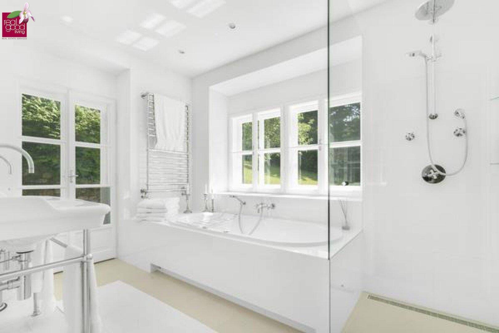 Modernes, helles Badezimmer mit Badewanne, Regendusche und Fenster.
