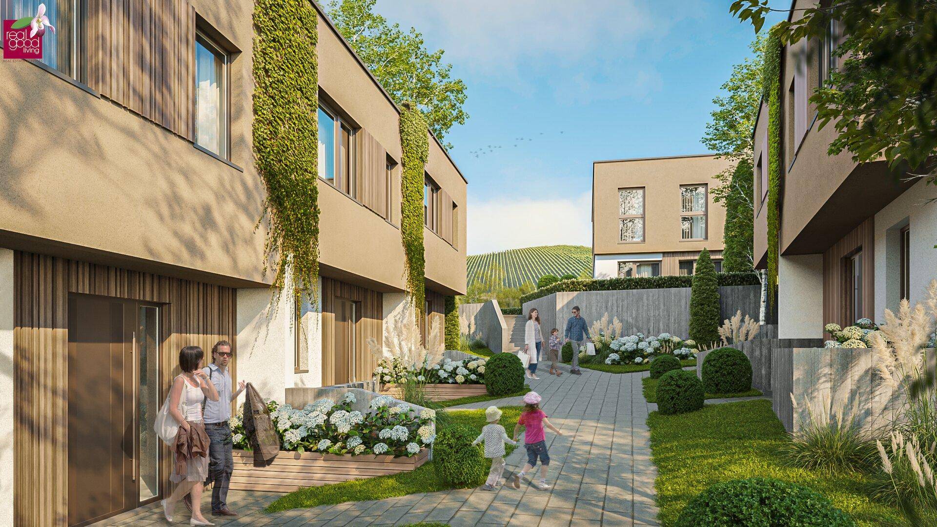 Gepflegte Außenanlage mit Wegen, Blumenbeeten und modernen Wohnhäusern vor Weinbergen.