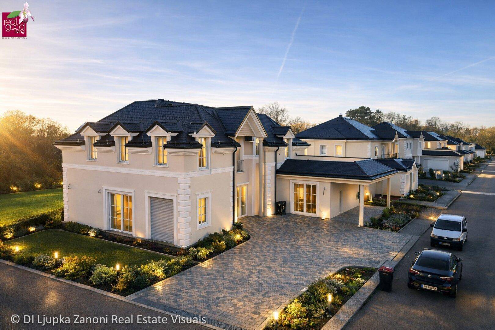 Außenansicht des luxuriösen Hauses mit gepflegter Auffahrt und Gartenbeleuchtung bei Sonnenuntergang.