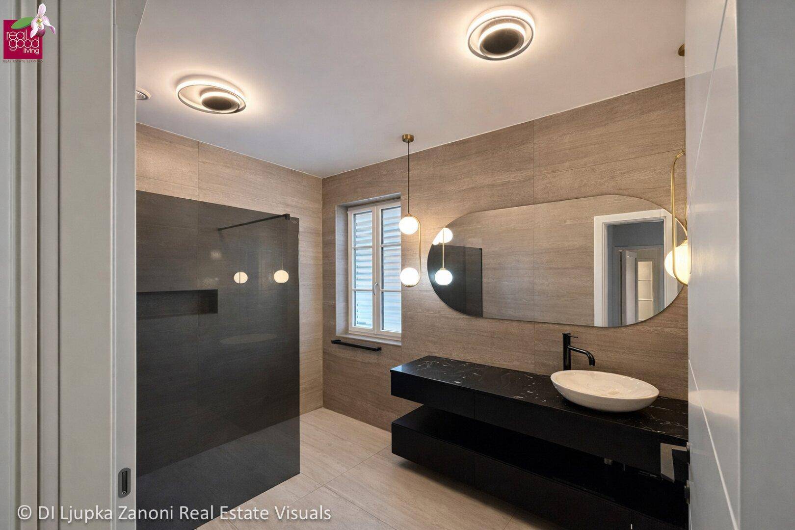 Elegantes Badezimmer mit modernem Waschbecken, großem Spiegel und begehbarer Dusche.
