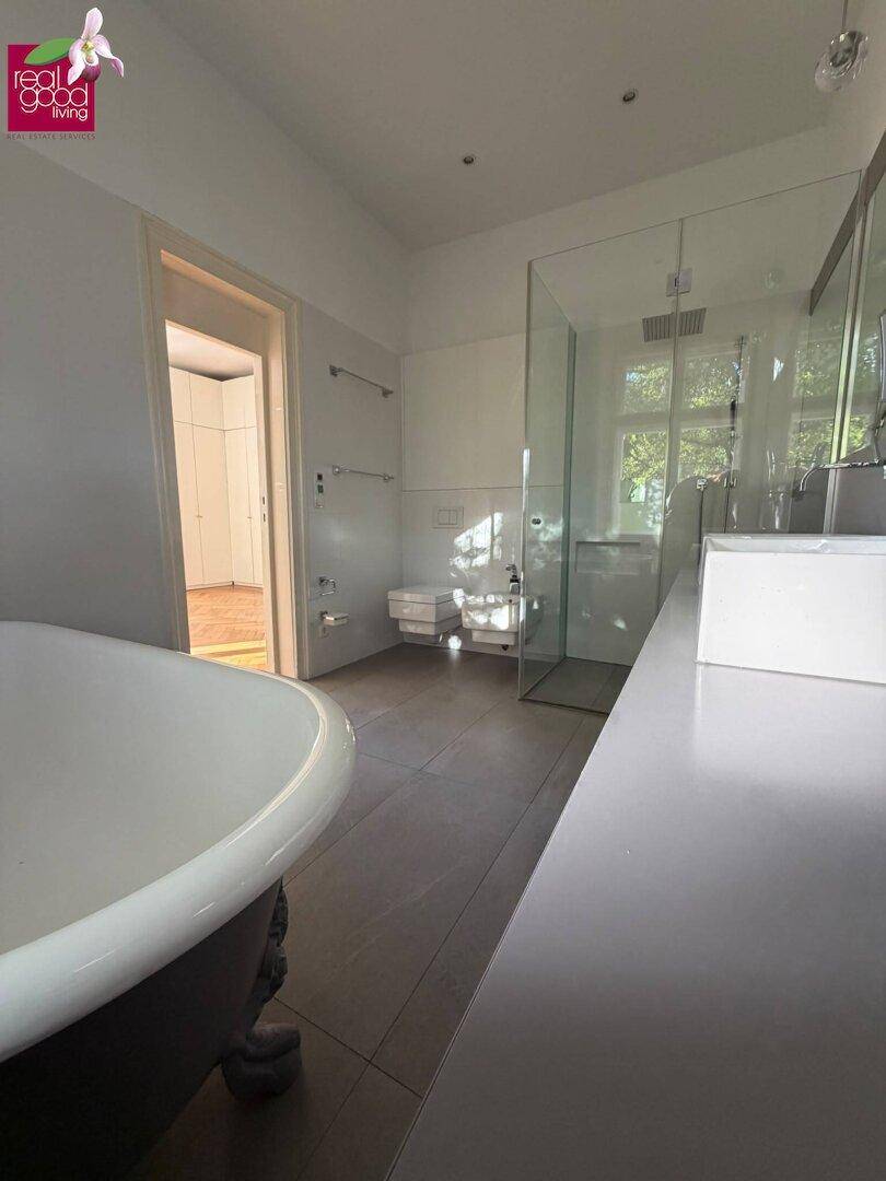 Elegantes Badezimmer mit freistehender Badewanne und geräumiger begehbarer Dusche.
