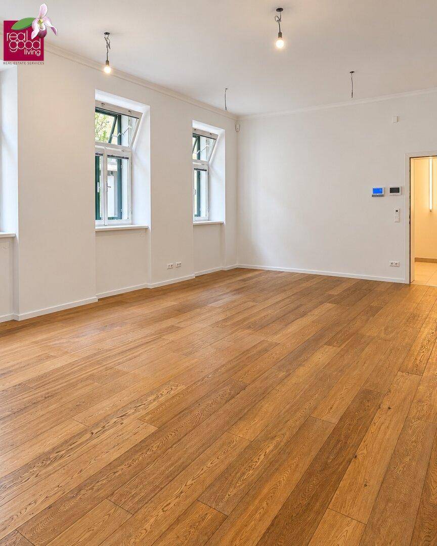 Weitläufiger Büroraum mit viel Tageslicht durch große Fenster und neu verlegtem, ansprechendem Holzboden.