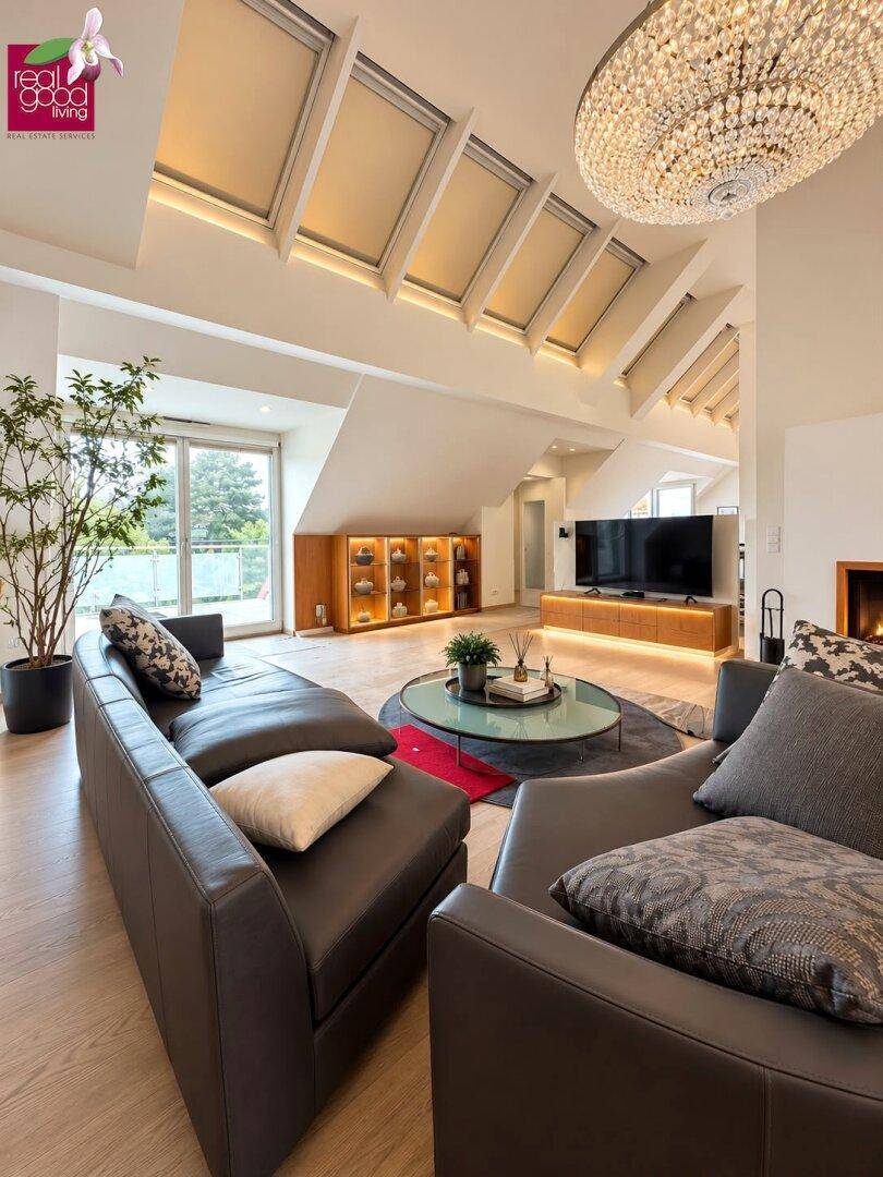 Helles Wohnzimmer im Dachgeschoss mit hohen Decken, Dachfenstern und modernem Kamin.