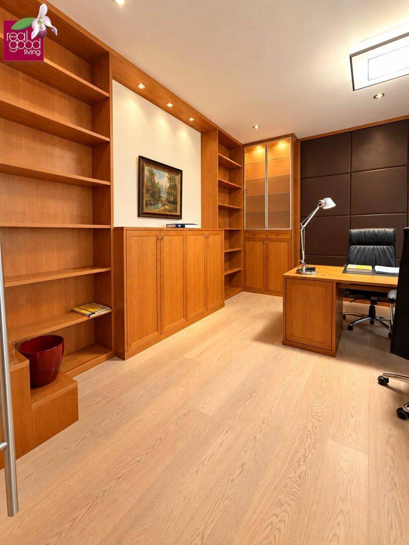 Helles Arbeitszimmer mit maßgefertigten Holzregalen, Schreibtisch und hellem Holzboden.