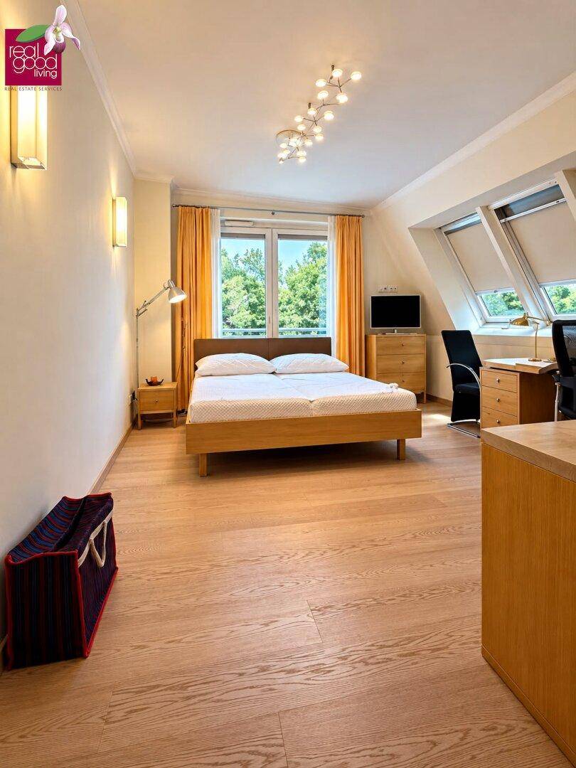 Schlafzimmer im Dachgeschoss mit Doppelbett, Schreibtisch und Dachfenstern für viel Licht.