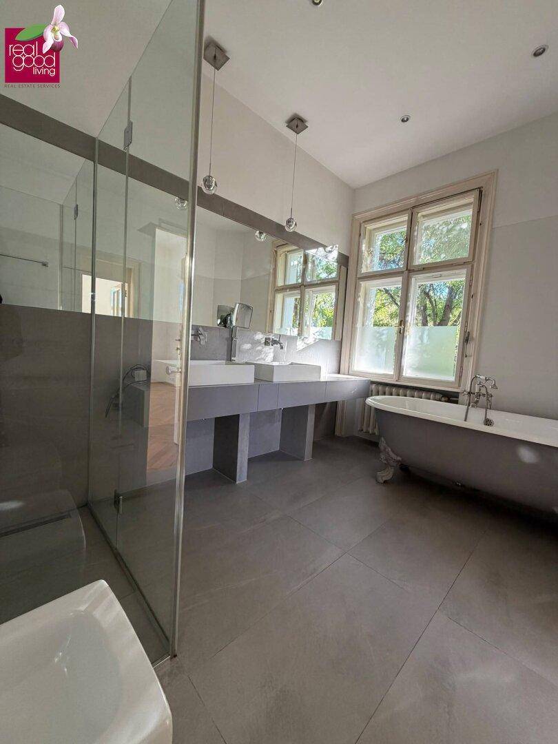Modernes Badezimmer mit Doppelwaschbecken, freistehender Badewanne und großer begehbarer Dusche.