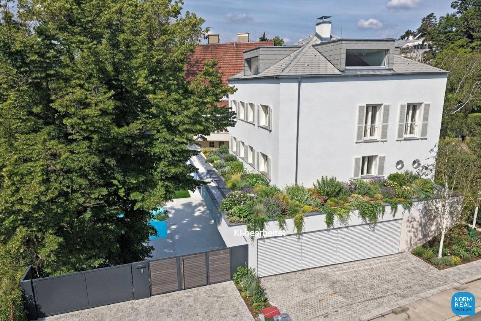 Ansicht der modernen Villa von oben mit Zufahrt, Garage und begrünter Dachfläche.