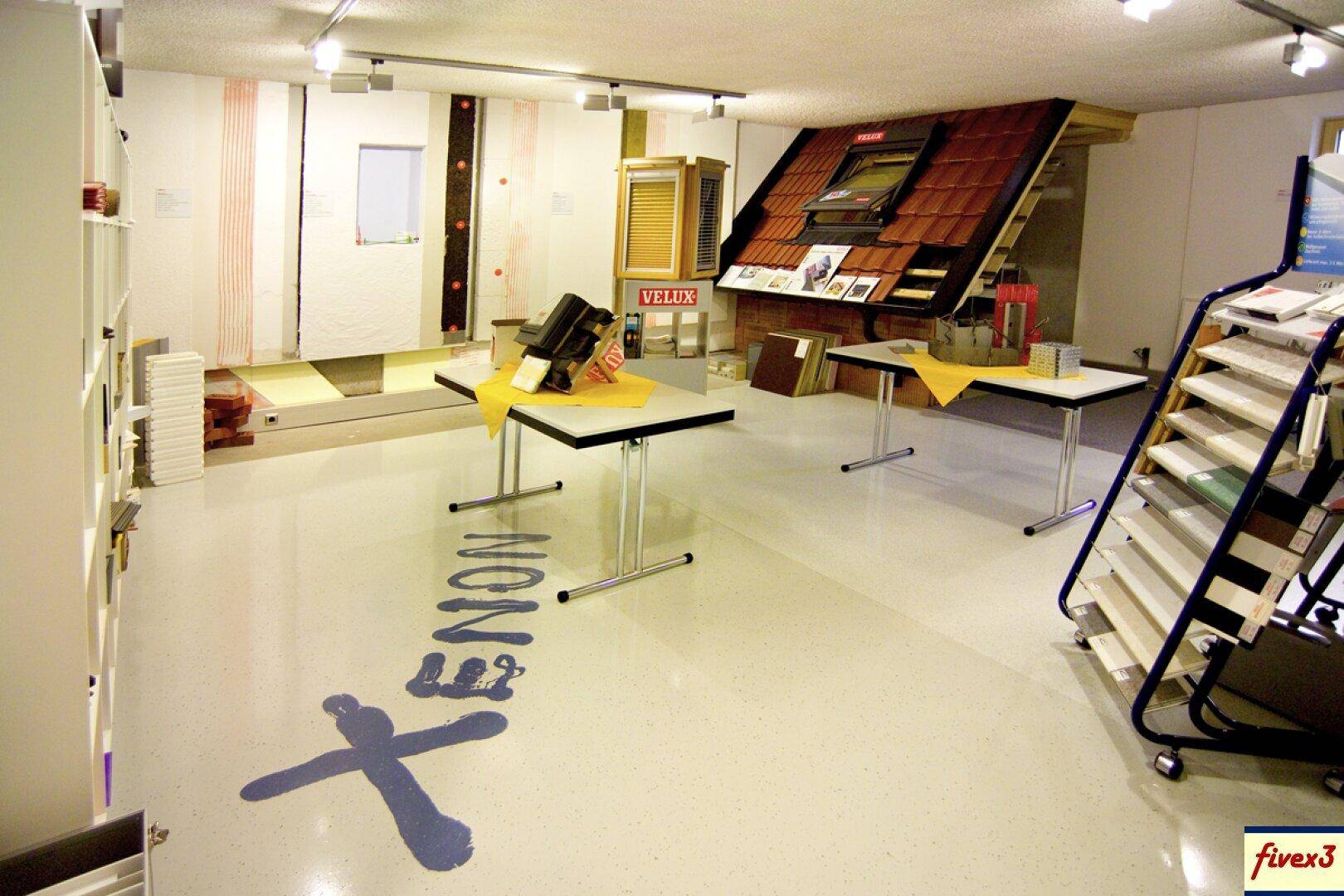 Ausstellungsraum für Baumaterialien und Fenster, mit verschiedenen Mustern und Präsentationen.