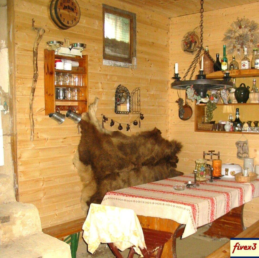 Gemütlicher Essbereich mit Holzwänden, einem gedeckten Tisch und einer Bank mit einem großen Fellüberwurf.