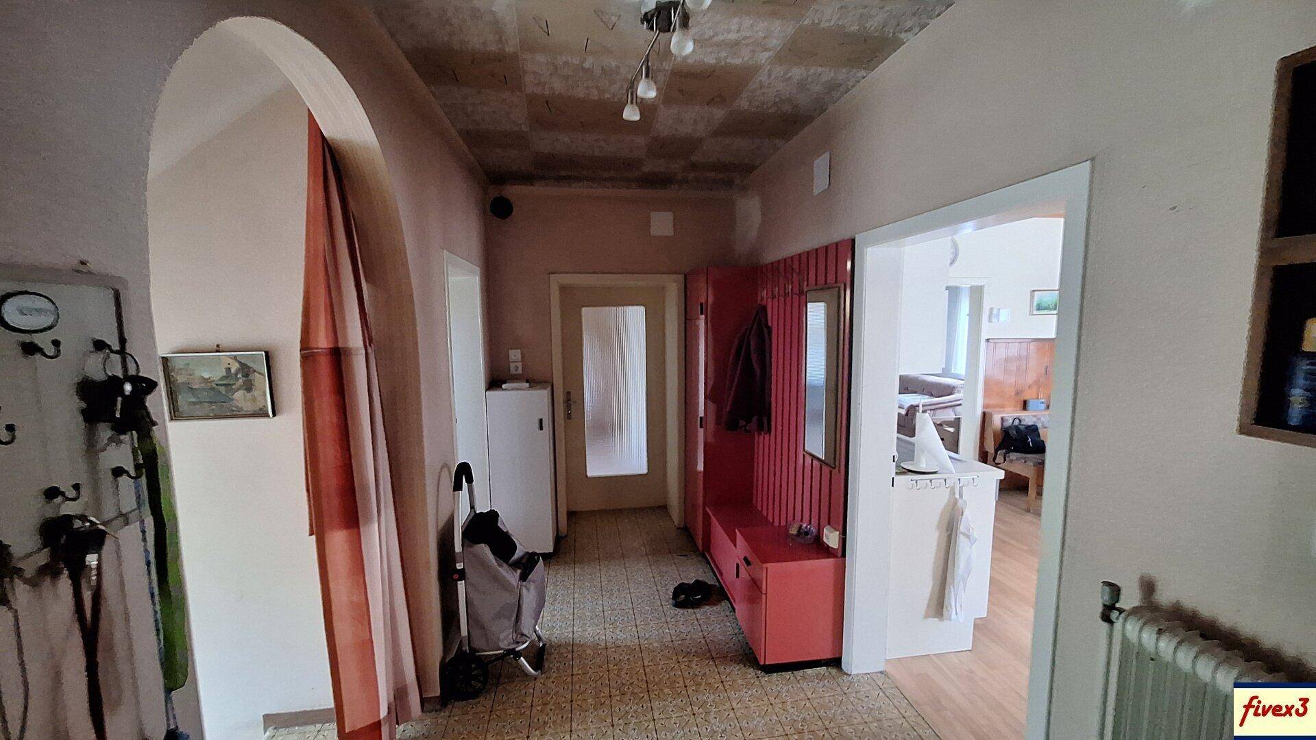 Flur mit gemustertem Boden, Garderobe und Zugang zu weiteren Räumen.