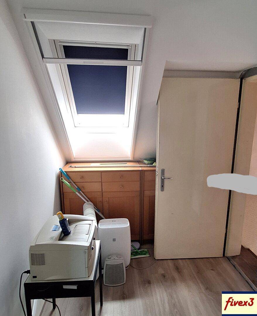 Dachbodenraum mit Dachfenster, Holzkommode und Stauraum unter der Dachschräge.