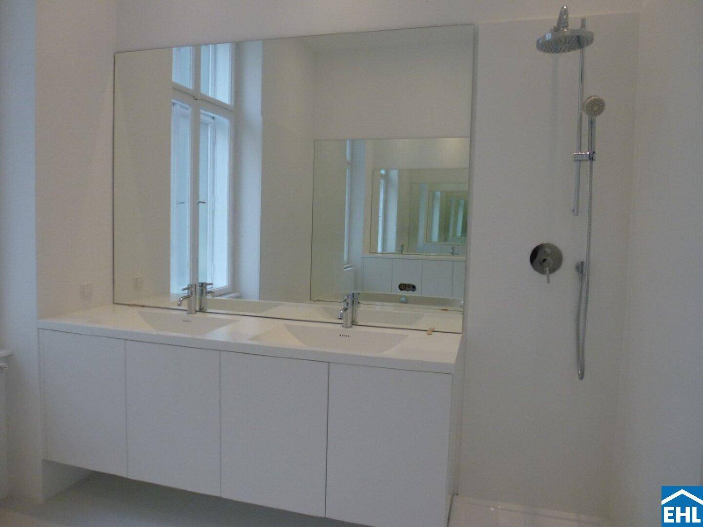 Modernes Badezimmer mit Doppelwaschbecken, großem Spiegel und Regendusche.