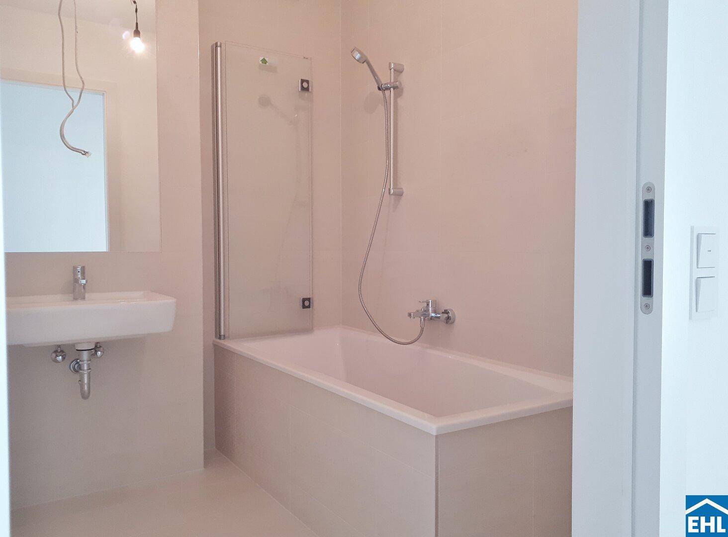 Modernes Badezimmer mit Badewanne, Duschabtrennung und einem einzelnen Waschbecken.