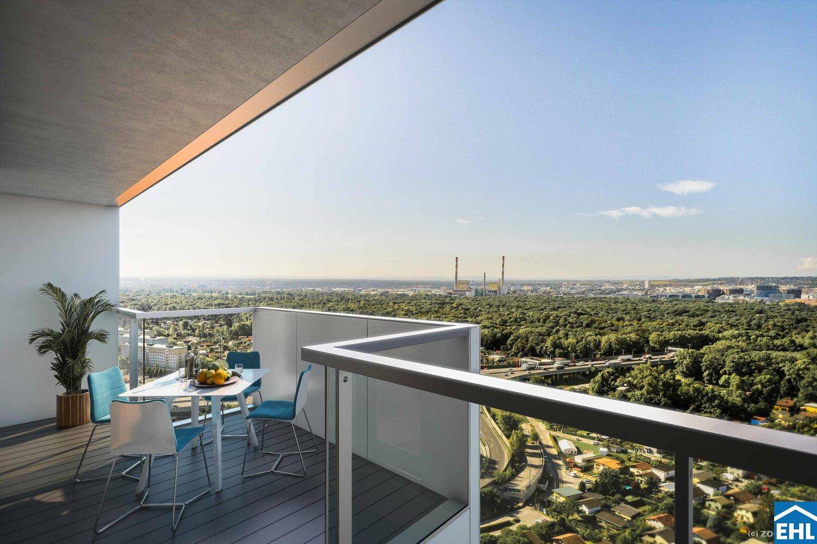 Sonniger Balkon mit Esstisch und weitem Blick über die grüne Umgebung.