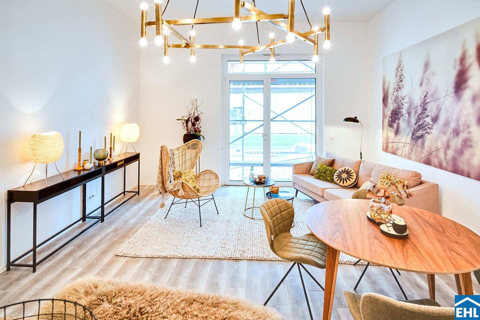 Gemütlicher Wohnbereich mit Sofa, Sessel und großem Fenster für viel Tageslicht.
