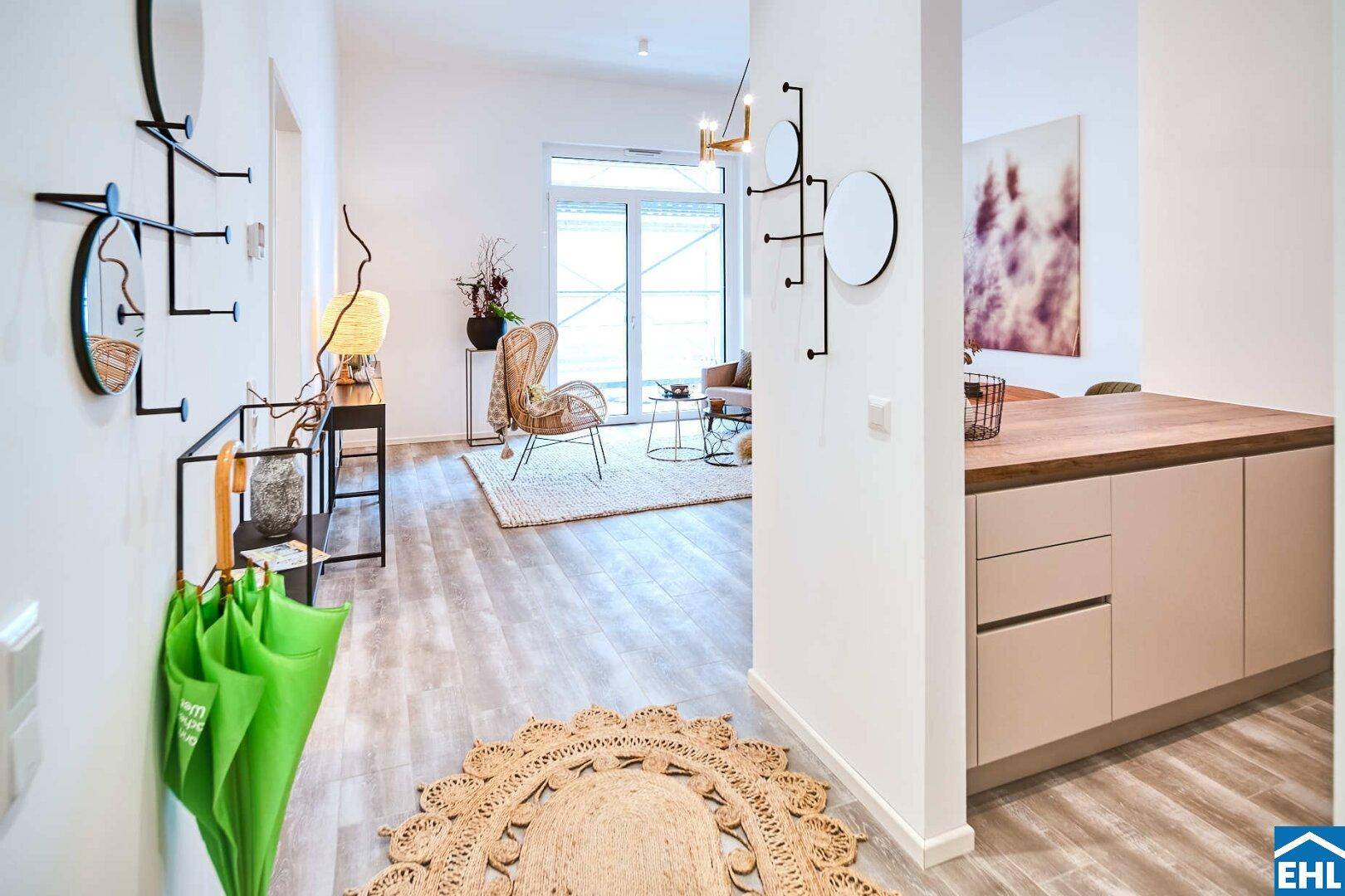 Heller Eingangsbereich mit Garderobe und Blick in den offenen Wohn- und Küchenbereich.
