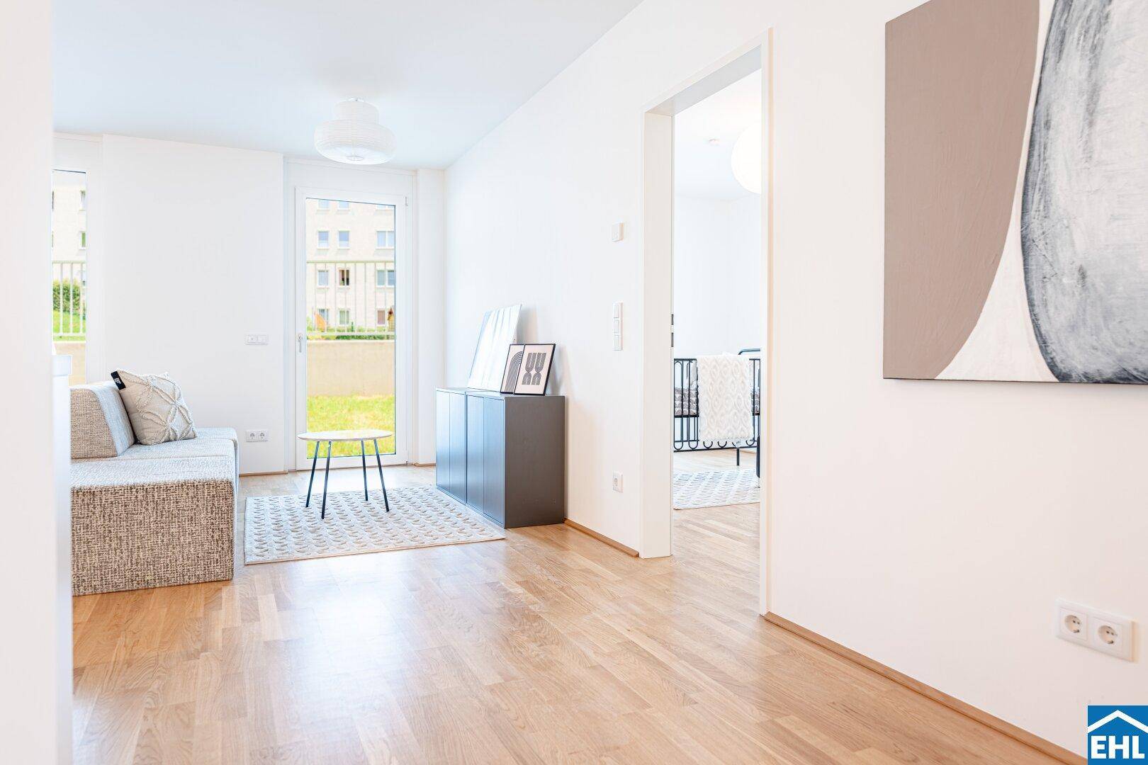 Gemütlicher Wohnbereich mit Sofa und Zugang zu einem Balkon oder Garten, hell und modern.