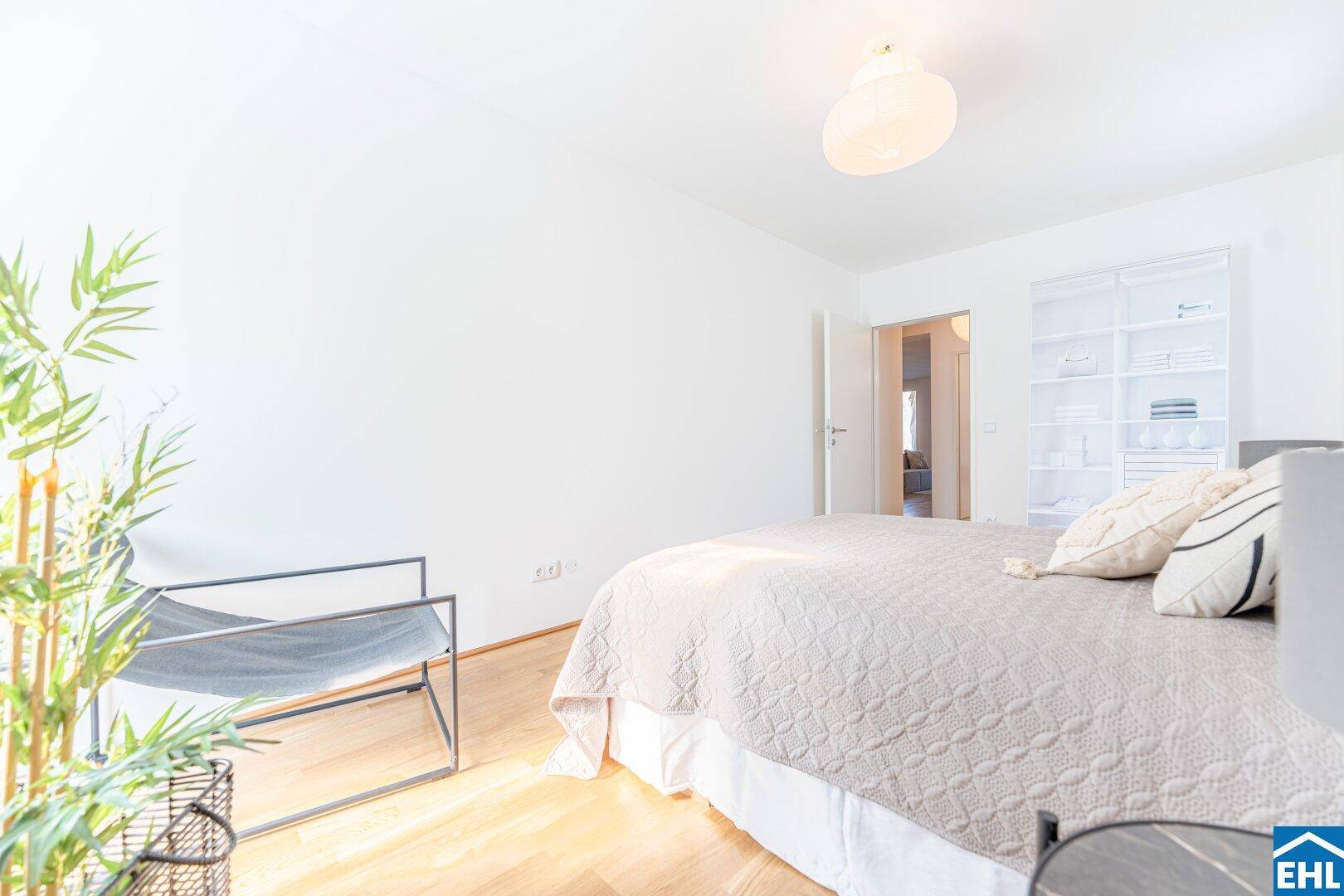 Geräumiges Schlafzimmer mit Doppelbett und offenem Regalsystem, hell und einladend.