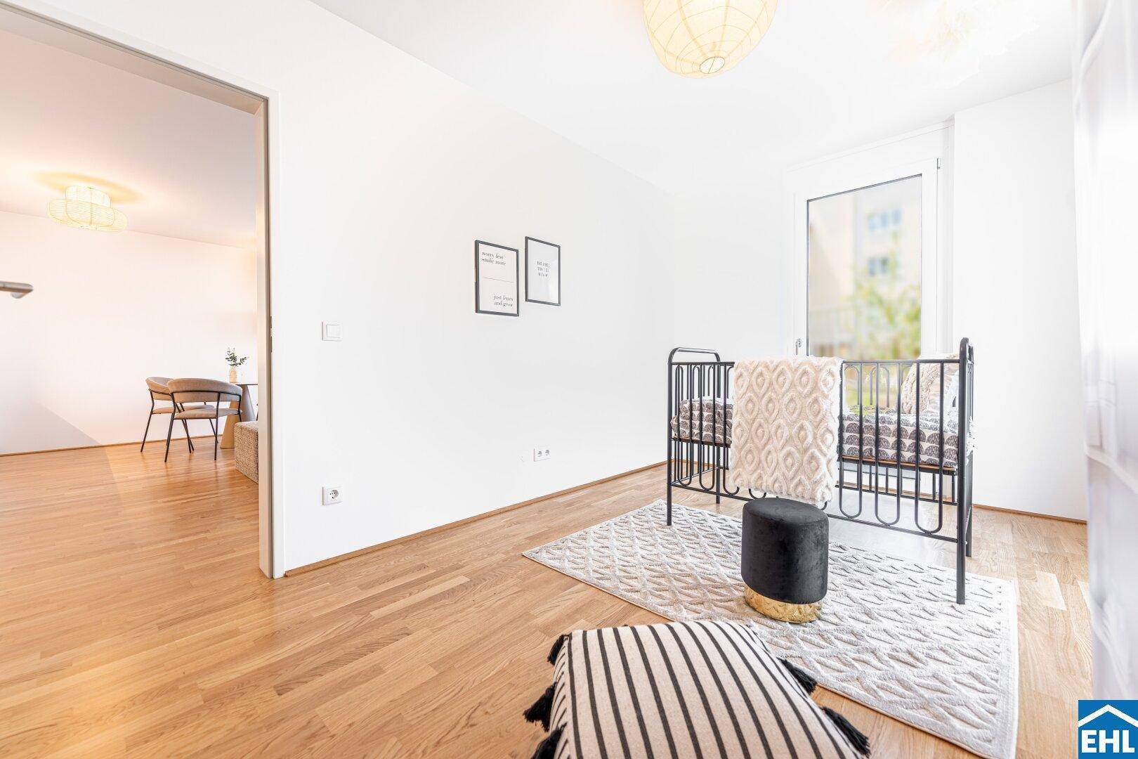 Helles Kinderzimmer mit Gitterbett und Blick in den offenen Wohnbereich.