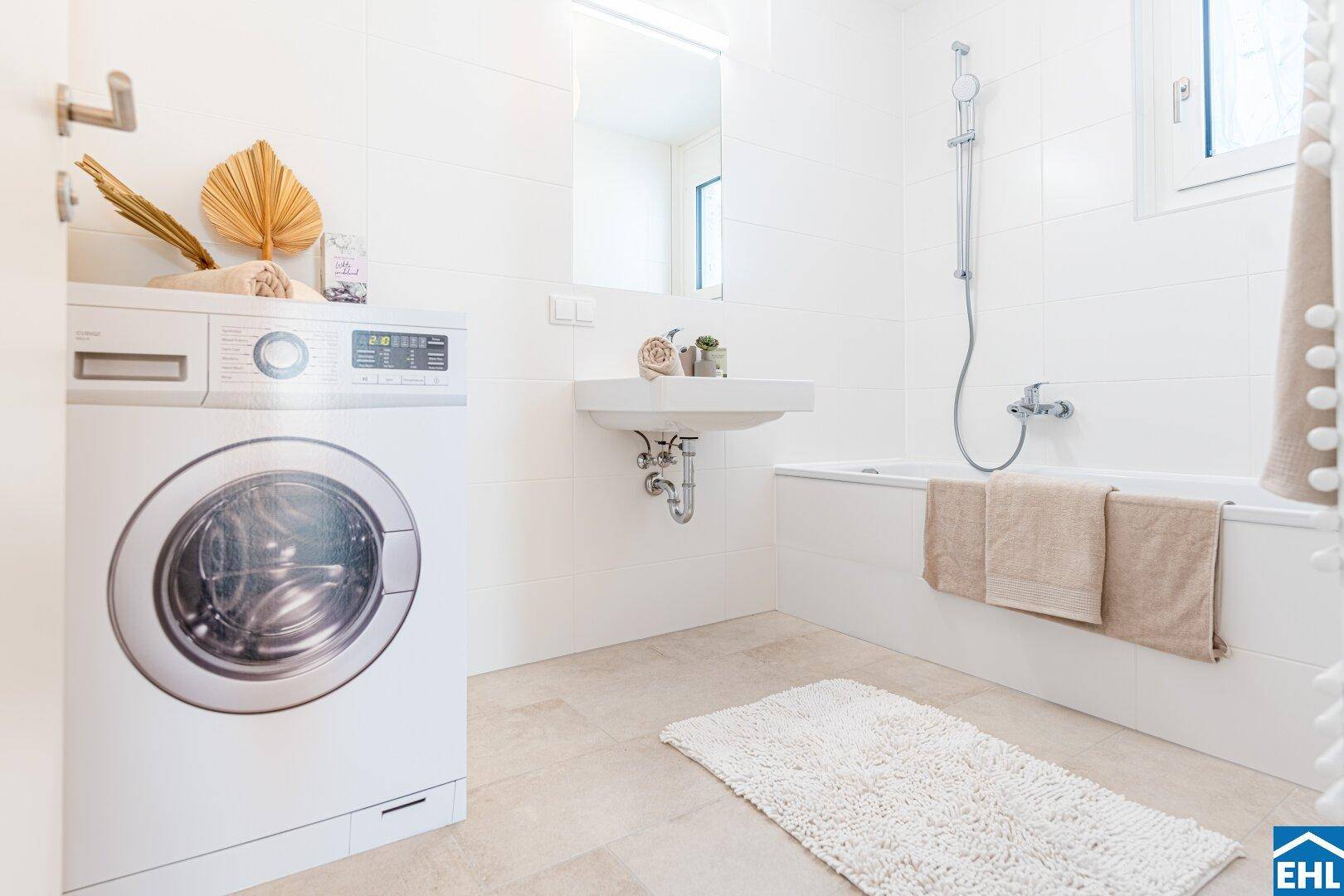 Badezimmer mit Waschmaschine, Waschbecken, Badewanne mit Duschfunktion und Fenster.