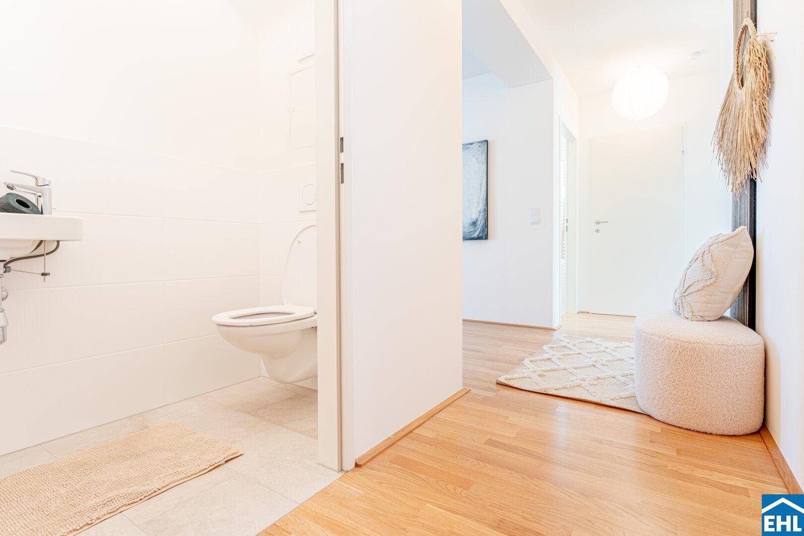 Modernes Gäste-WC mit wandhängendem WC und Waschbecken, angrenzend an den Flur.