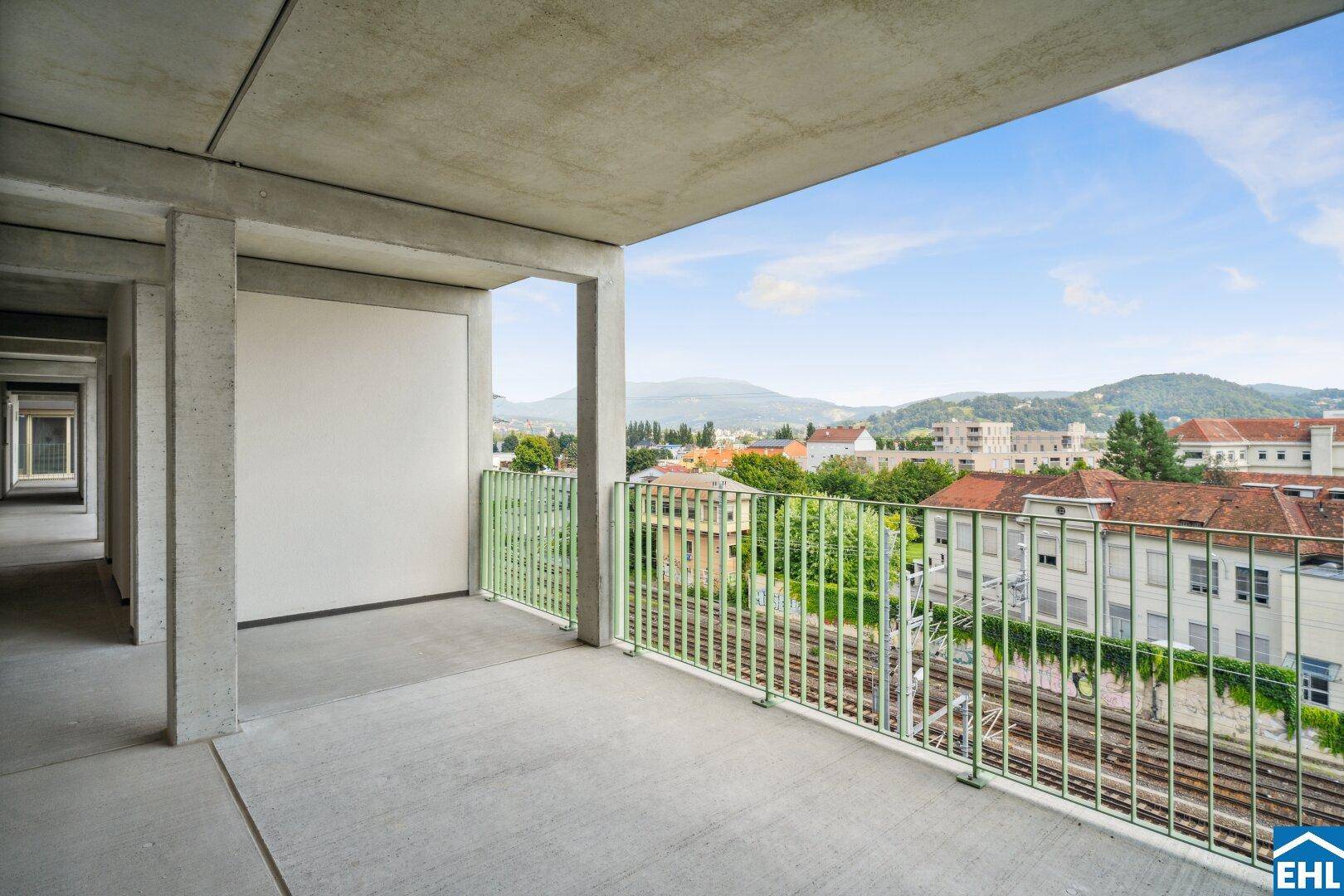 Breiter Balkon mit weitem Blick über die Stadt und Bahngleise.