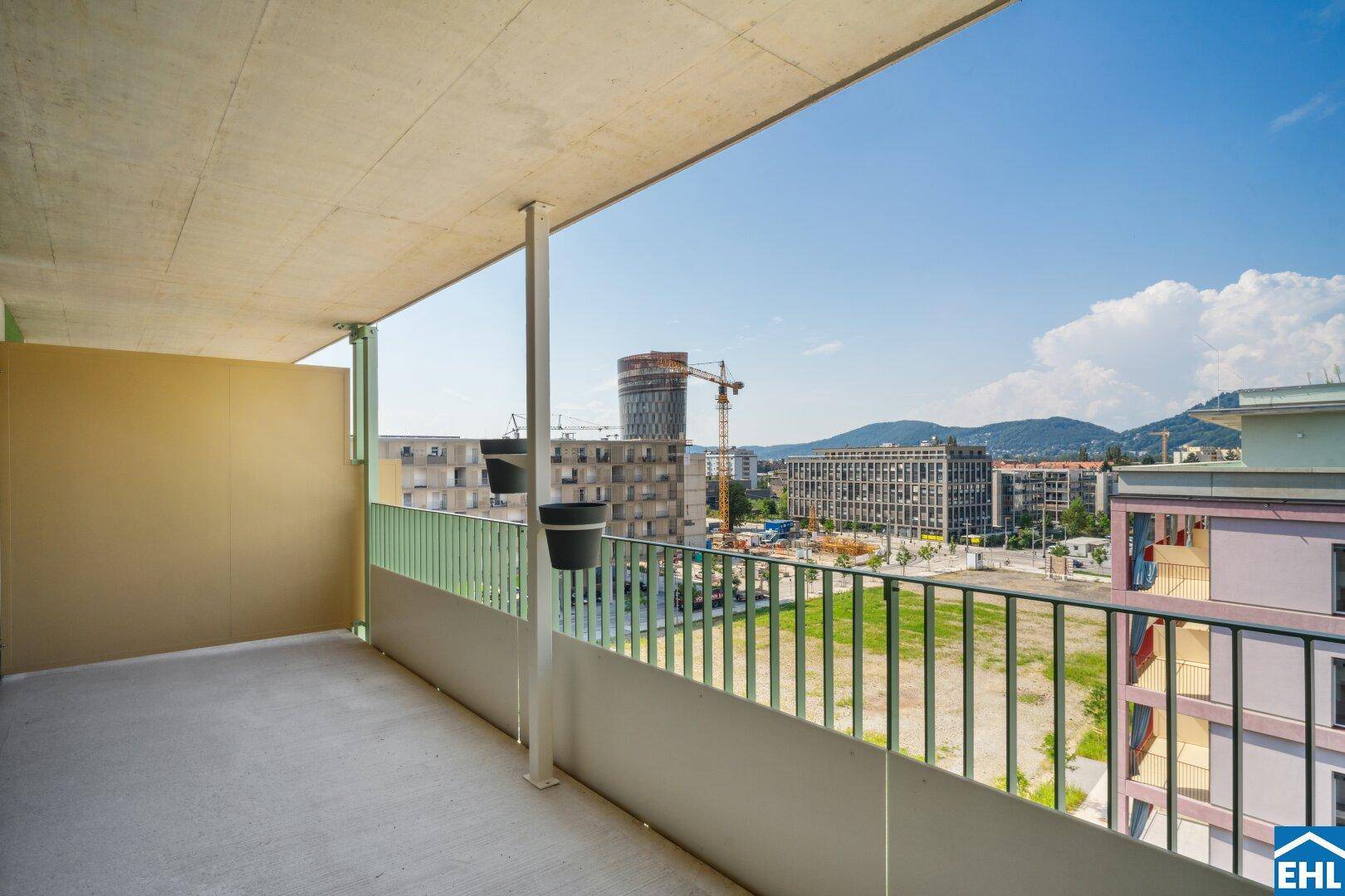 Geräumiger Balkon mit Stadtblick und Blick auf die Berge im Hintergrund, ideal zum Entspannen.