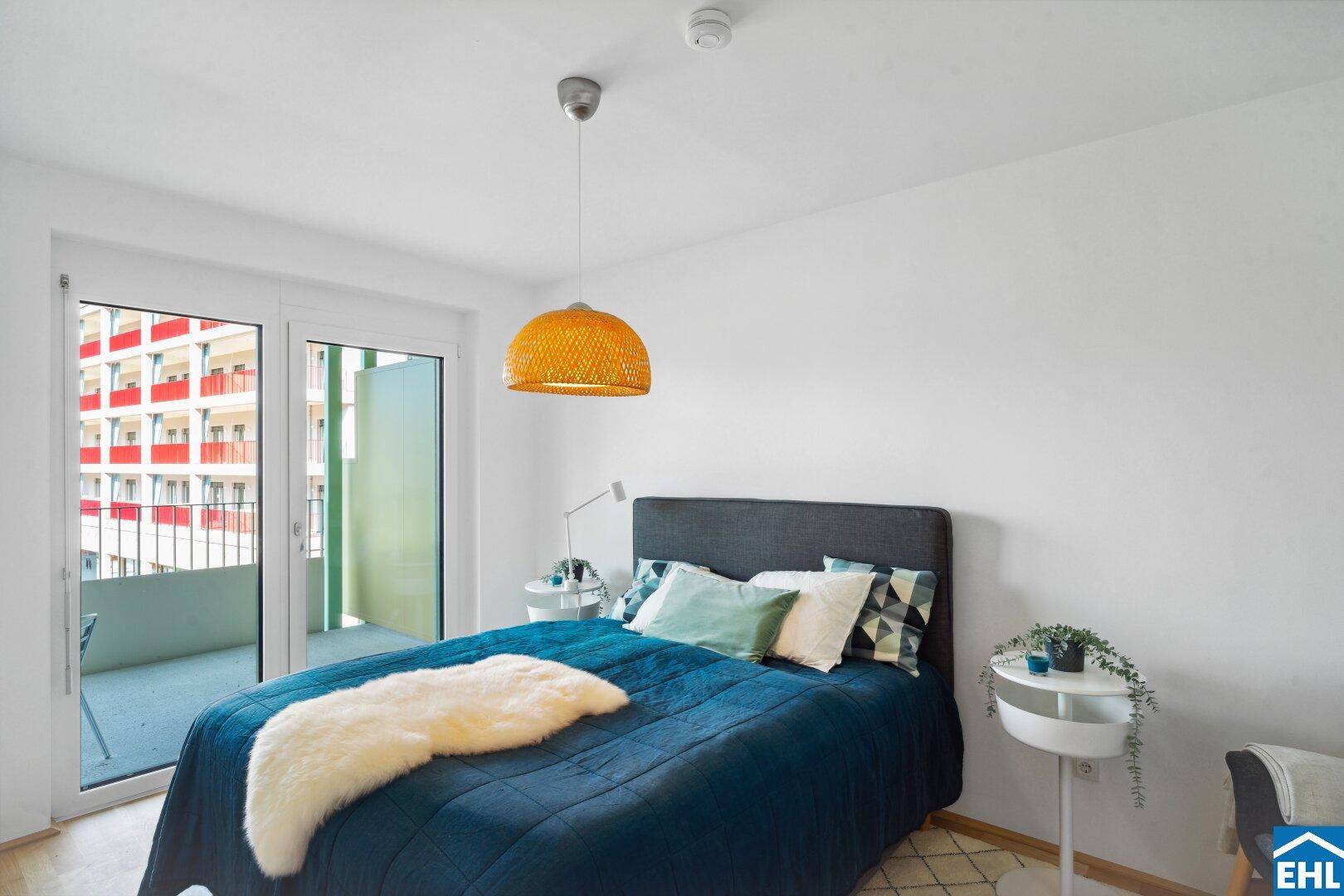 Schlafzimmer mit Doppelbett, Balkonzugang und hellem Holzboden.