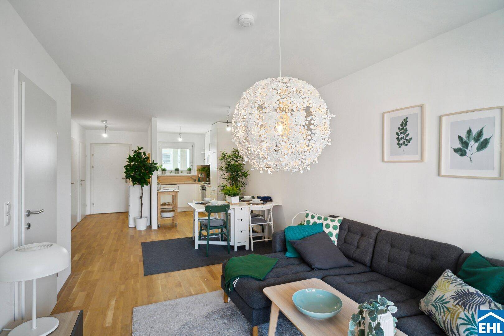 Heller offener Wohn- und Essbereich mit Holzboden und moderner Einrichtung, ideal für geselliges Beisammensein.