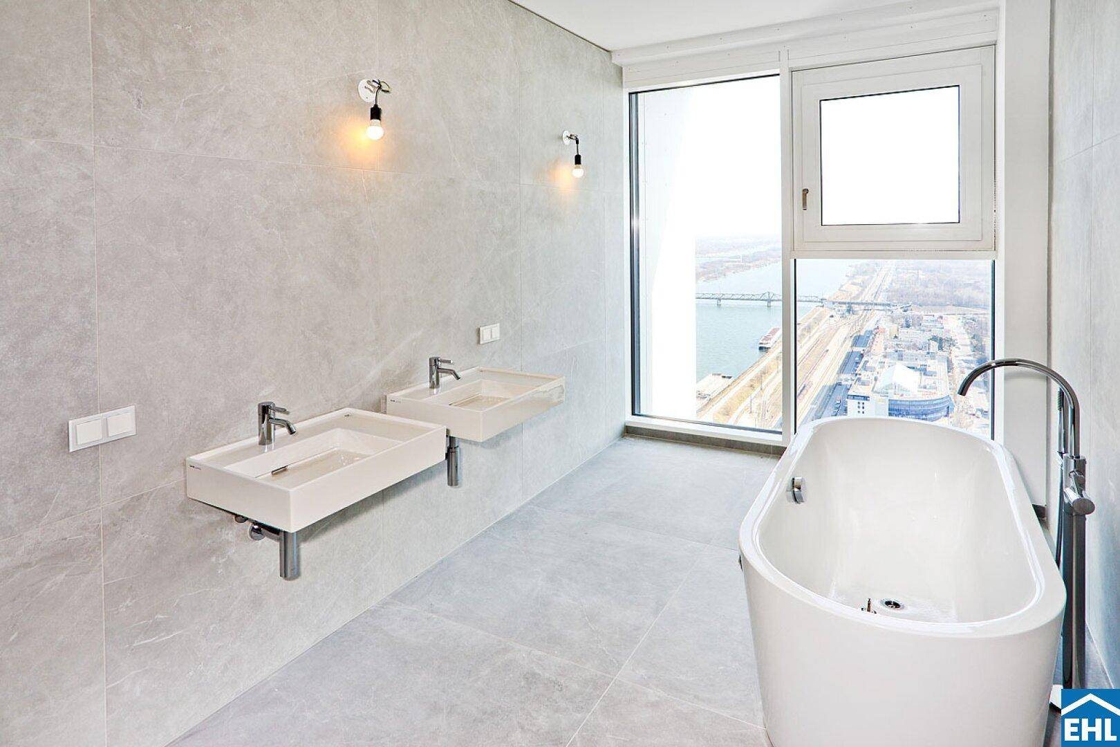 Modernes Badezimmer mit freistehender Badewanne, Doppelwaschbecken und großem Fenster mit Flussblick.