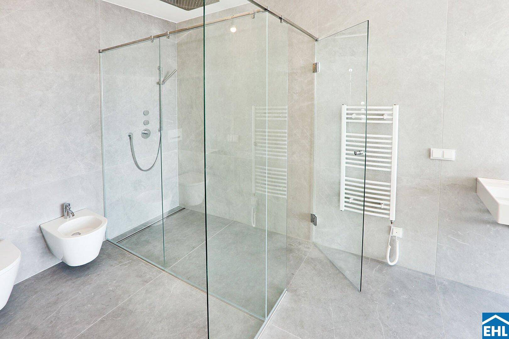 Elegantes Badezimmer mit großer begehbarer Dusche, Bidet und beheiztem Handtuchhalter.