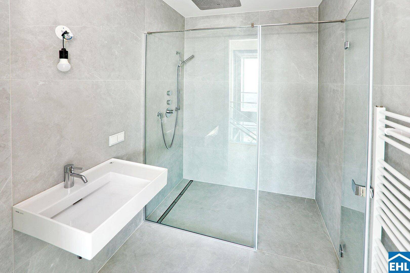 Modernes Badezimmer mit begehbarer Dusche, Einzelwaschbecken und stilvollen Armaturen.