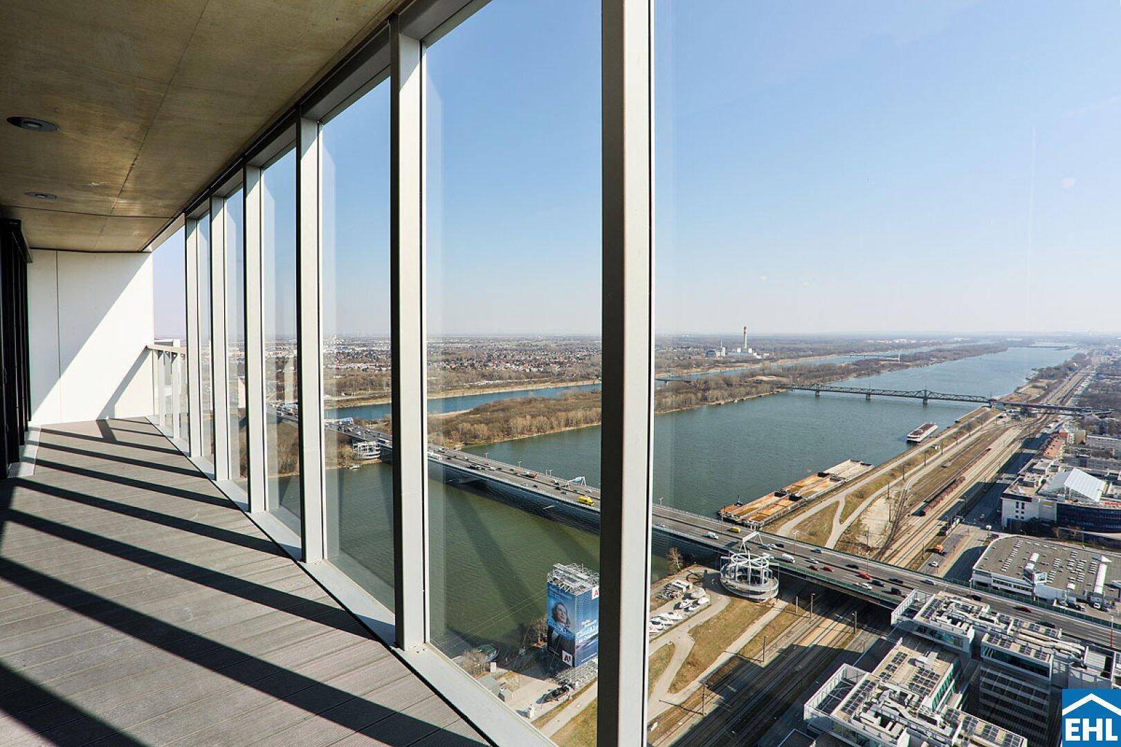 Große Fensterfronten bieten einen spektakulären Blick vom Balkon auf den Fluss und die Stadt.