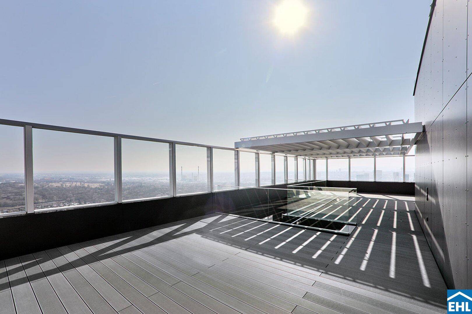 Geräumige Dachterrasse mit Pergola und weitem Blick über die Stadt und die Landschaft.