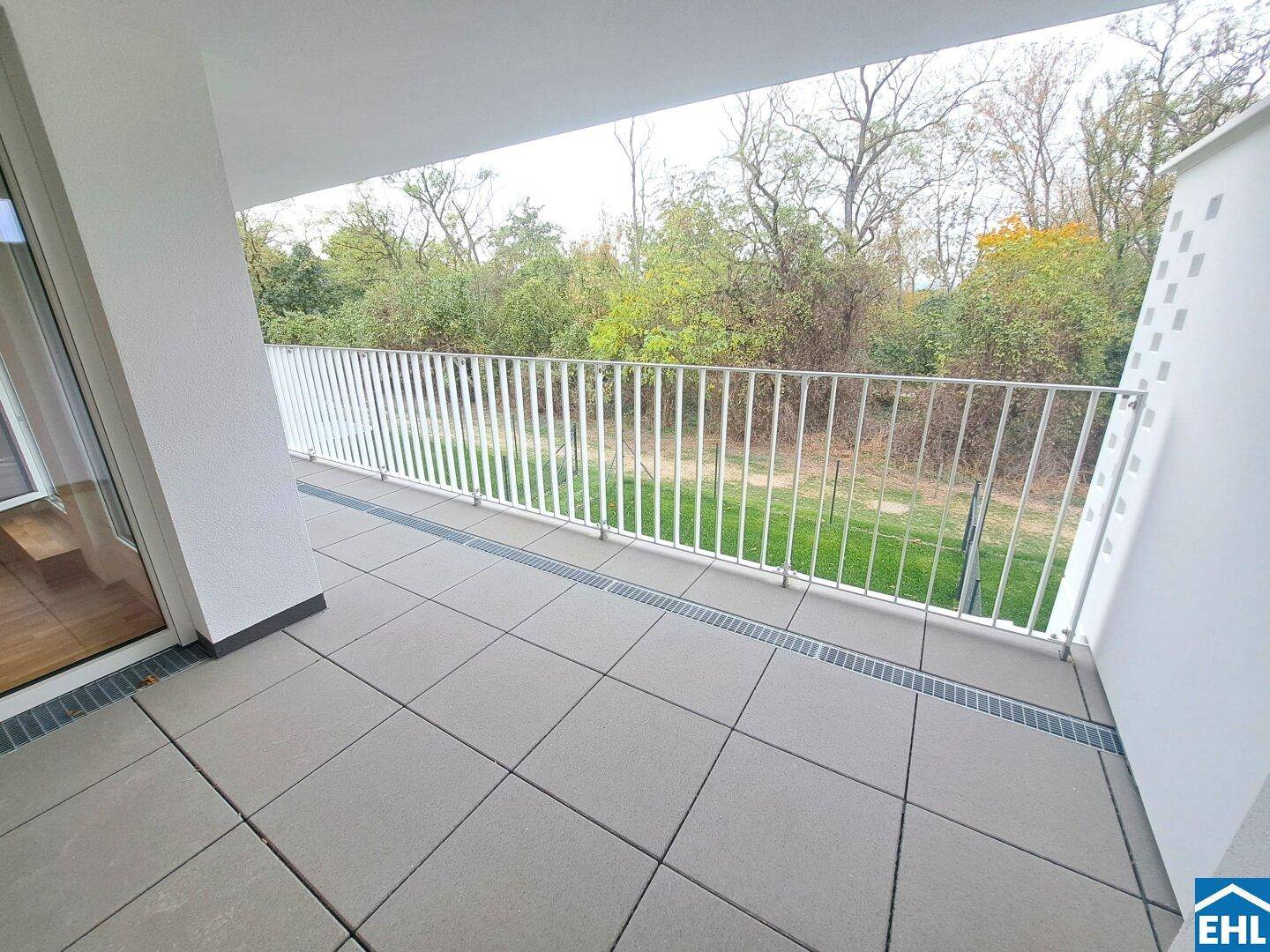 Geräumiger Balkon mit Fliesenboden und Blick ins Grüne, ideal zum Entspannen.