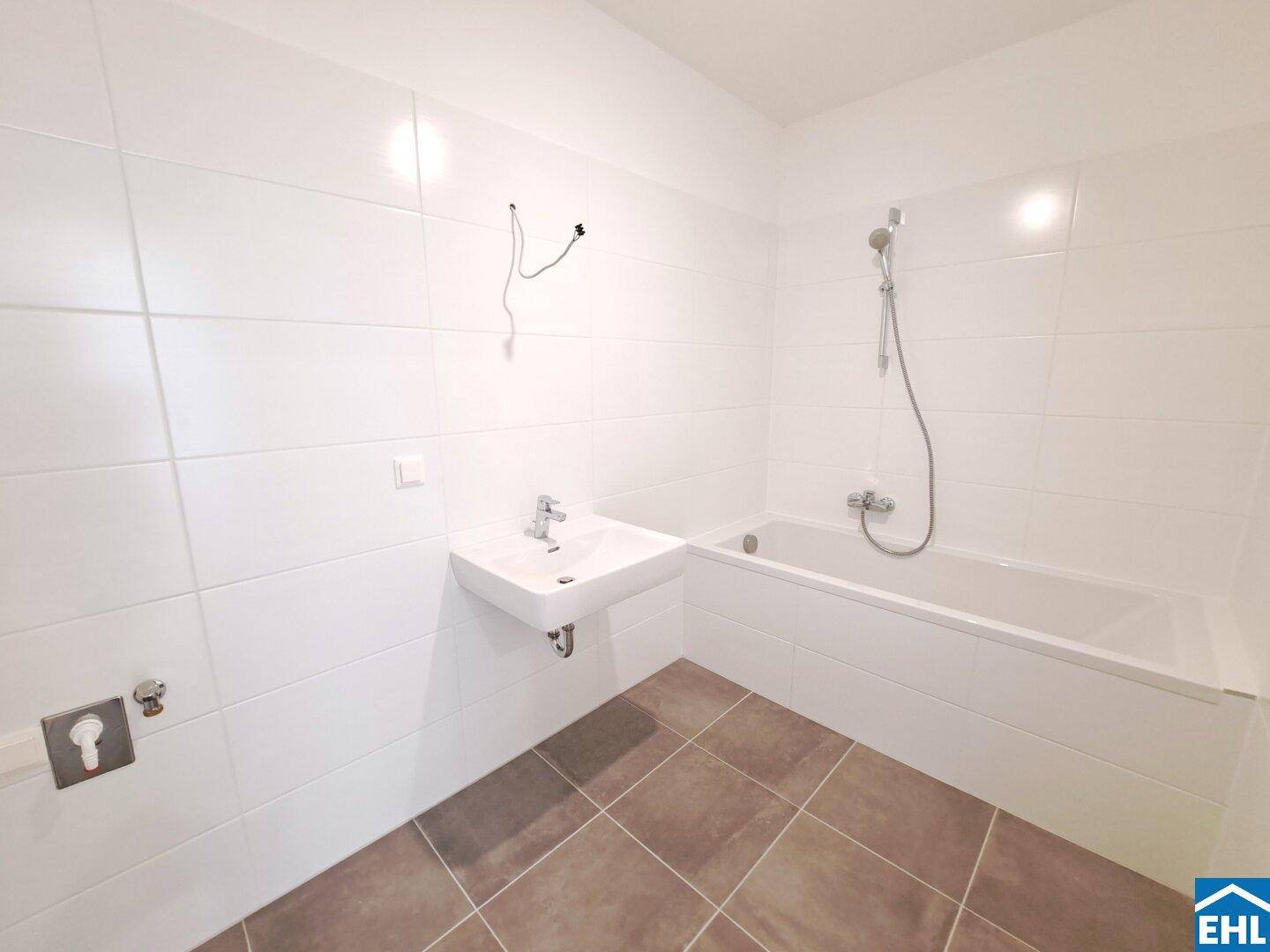 Modernes Badezimmer mit Badewanne, Einzelwaschbecken und weißen Fliesen.