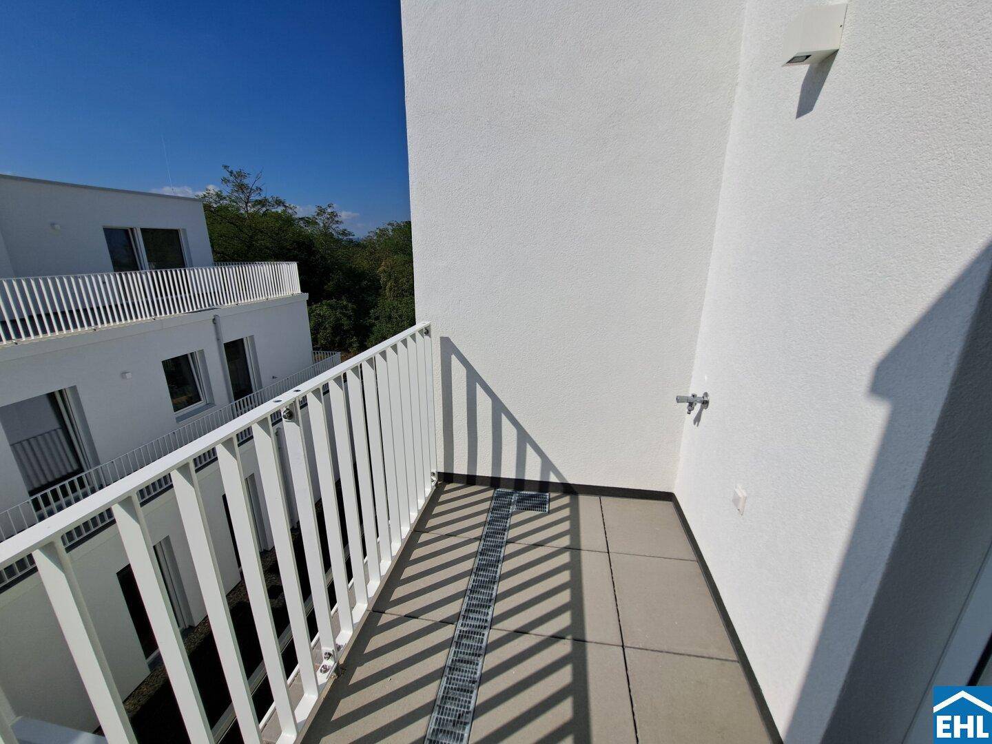 Kleiner Balkon mit Fliesenboden und Metallgeländer, bietet einen Blick auf die Umgebung.