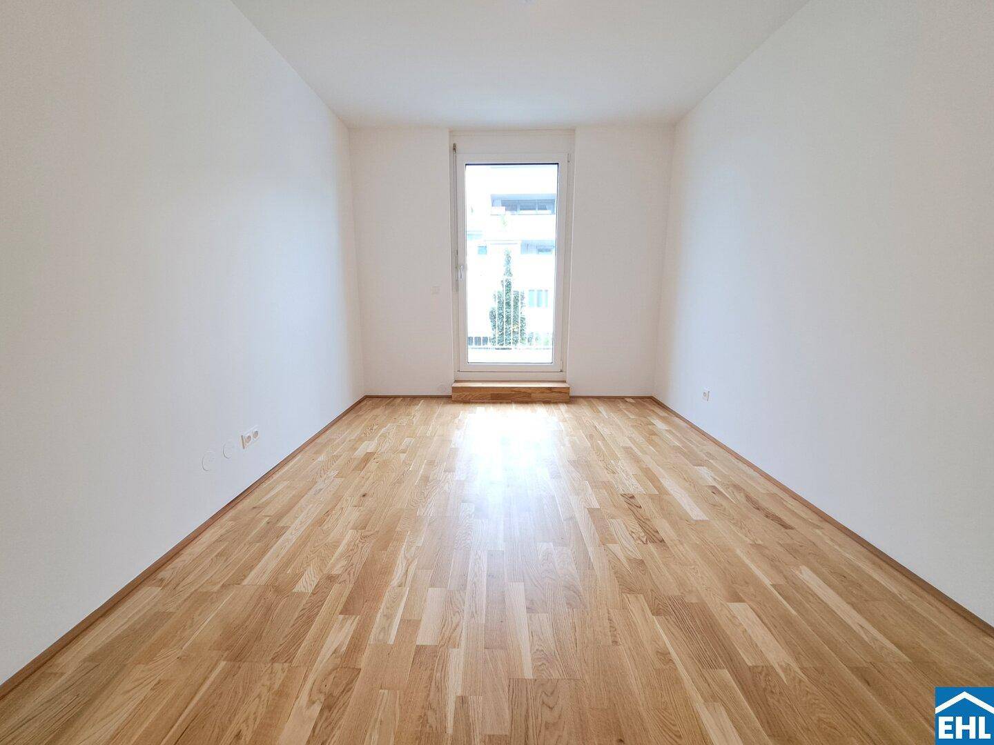 Ruhiges Schlafzimmer mit Zugang zu einem französischen Balkon und hochwertigem Parkettboden.