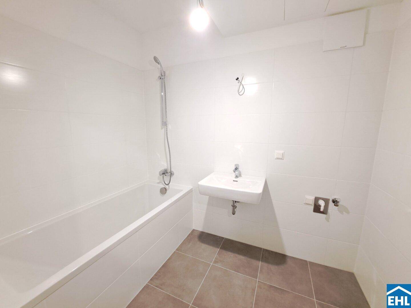Modernes Badezimmer mit Badewanne, Waschbecken und weißen Fliesen.