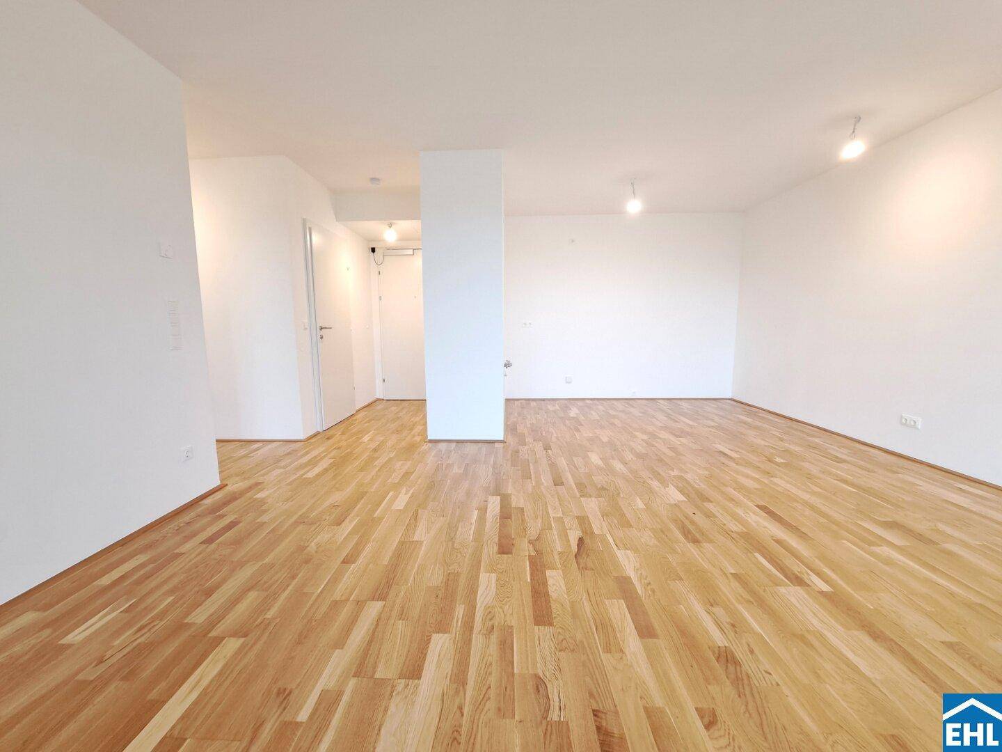 Geräumiges, helles Zimmer mit Parkettboden und Zugang zu einem Flur, bereit zum Einzug.