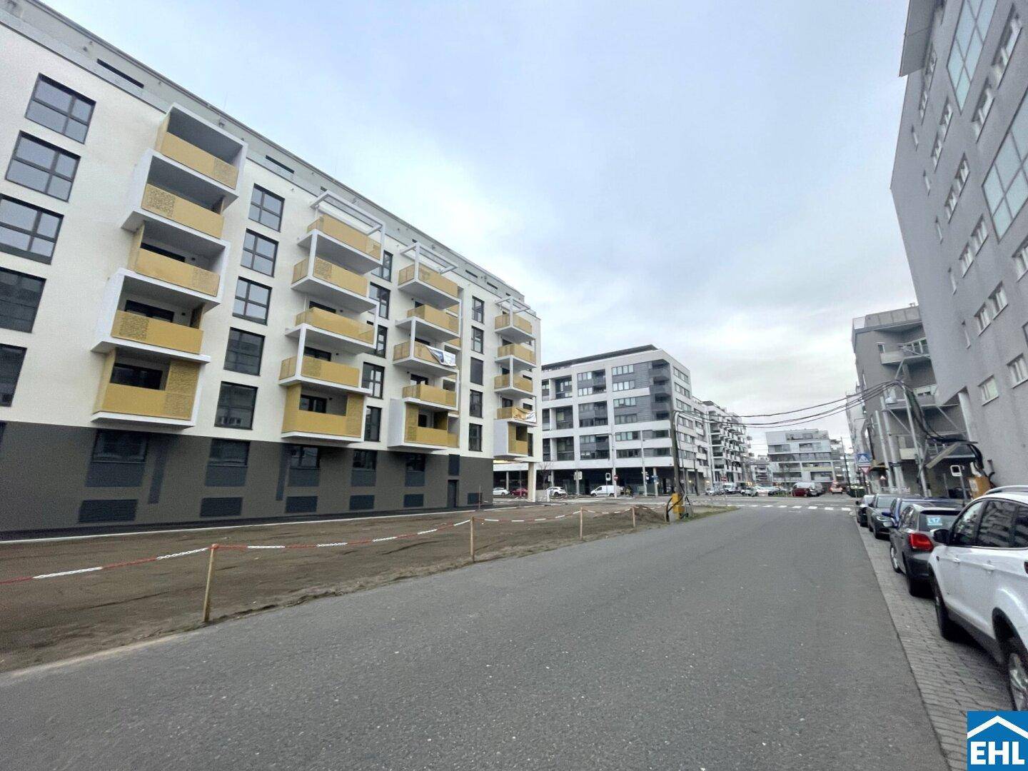 Moderne Wohngebäude entlang einer Straße mit Balkonen und zeitgenössischer Architektur.