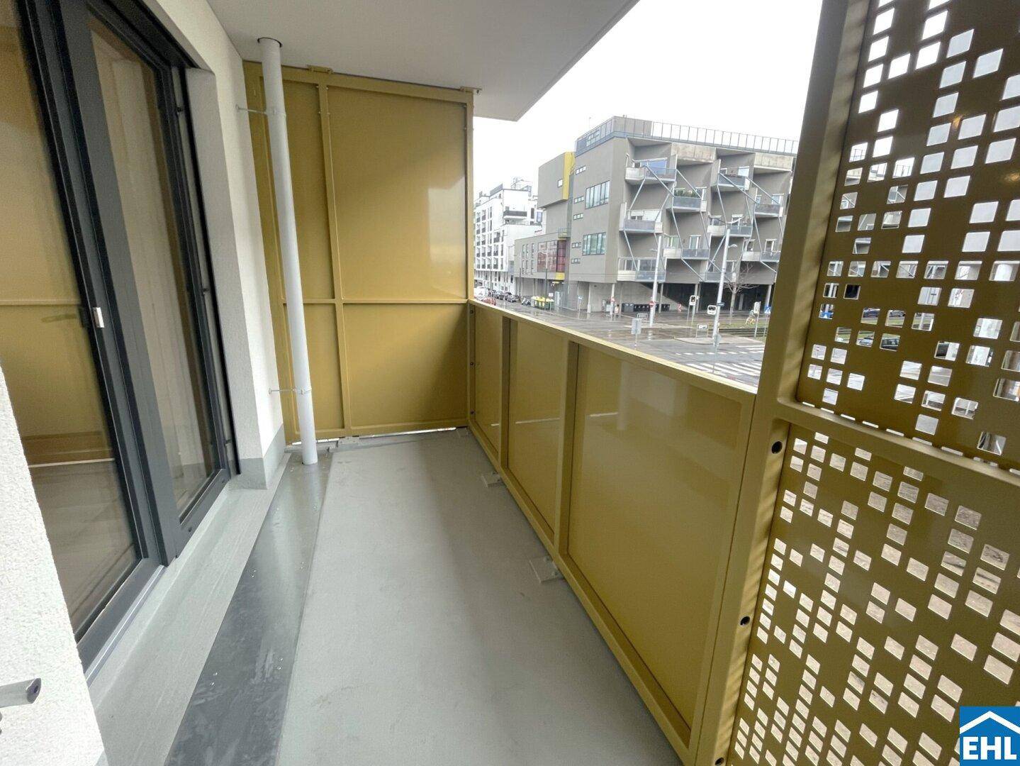 Heller Balkon mit modernen Sichtschutzelementen und Blick auf die umliegende Stadtbebauung.