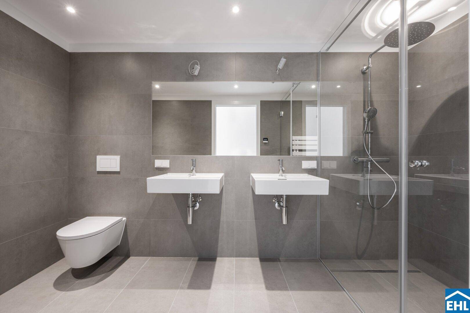 Modernes Badezimmer mit Doppelwaschbecken, bodengleicher Dusche und Wand-WC.